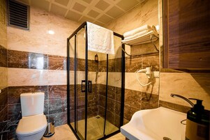 Un baño moderno con ducha envuelta en vidrio, inodoro y bañera.