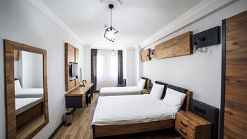 Een moderne hotelkamer met een groot bed, twee nachtkastjes, een bureau, een stoel en een televisie.