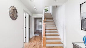 A staircase with wooden steps leading to a landing. - Three Story Home With Urban Courtyard Minutes to Downtown (Nashville)
