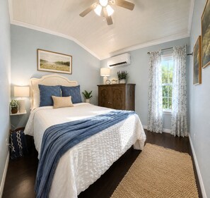 A bedroom with a bed, a nightstand, a dresser, a ceiling fan, and a window with curtains. - Lake Sam Rayburn "True" Waterfront Escape - Bring Boat, Kayak & Fishing Poles! (Etoile)