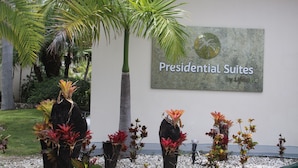 Une enseigne indiquant « Presidential Suites by Lifestyle », avec un jardin tropical en devant.