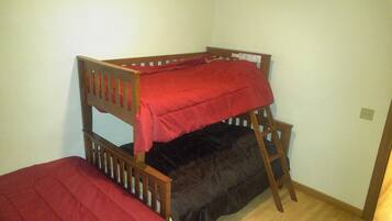 A bunk bed with a red blanket on top and a black blanket on the bottom.