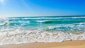 A beach with waves, clear sky, and a distant horizon. - Clown Fish Cottage - Pet Friendly with King Bed (Mexico Beach)