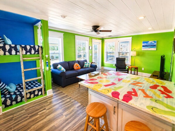A room with bunk beds, a sofa, a coffee table, and a TV.