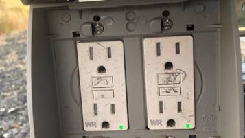 A utility box with two white electrical outlets, each marked with 'WR' and a green grounding symbol.