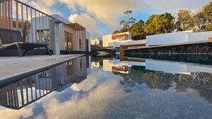 Un espace piscine moderne, avec des reflets nets, une architecture contemporaine et une vue sur les bâtiments environnants.