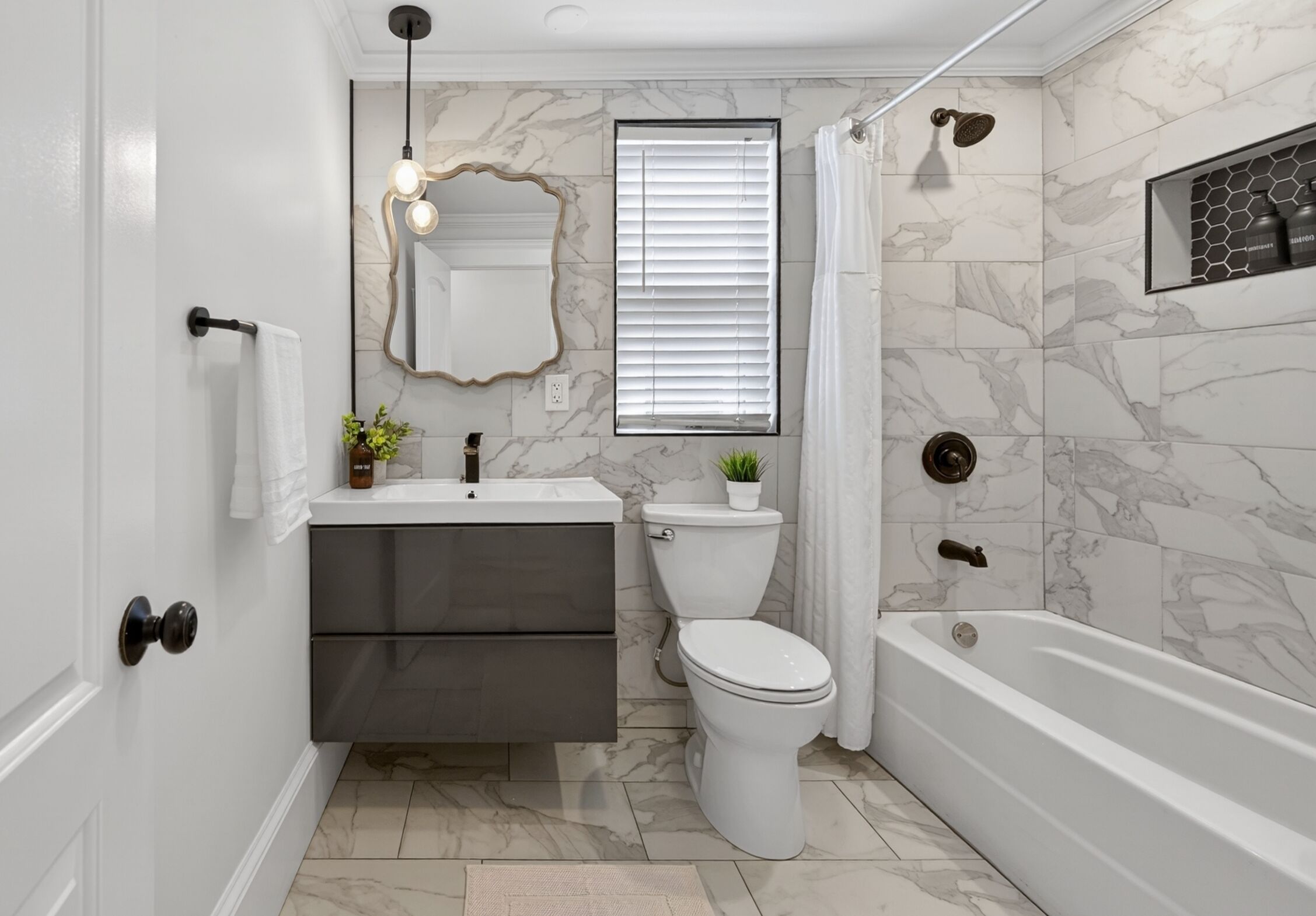 Een badkamer met toilet, wastafel, badkamermeubel en bad.