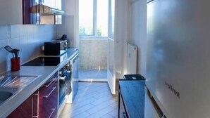 A modern kitchen with a large window, a whiteboard, and a tiled floor. - Appart'Hôtel L'ile en Mouvement (Montbéliard)
