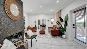 Un salon moderne avec une cheminée, deux canapés, une table basse et un coin repas.