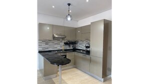 A modern kitchen with a central island, stainless steel appliances, and a checkered backsplash.