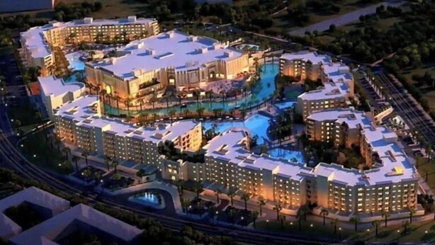 A large hotel complex with multiple buildings, a central pool area, and a beachfront view.