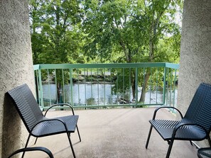 Sit and enjoy the tranquil views of the water and lush greenery from this serene outdoor seating area.