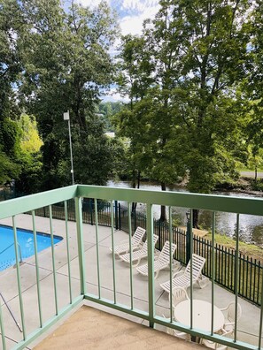 Relax by the serene pool overlooking the river, surrounded by lush greenery and a tranquil atmosphere.