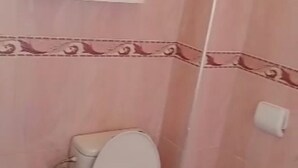 A bathroom with a toilet, a sink, and a mirror.
