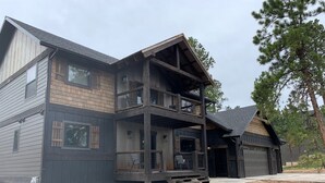 Une maison à deux étages avec un balcon, un garage et une allée.