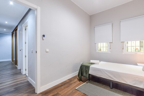 Een slaapkamer met een bed, een raam en een deur.