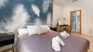 Ett modernt hotellrum med en stor säng, ett skrivbord och utsikt över staden.