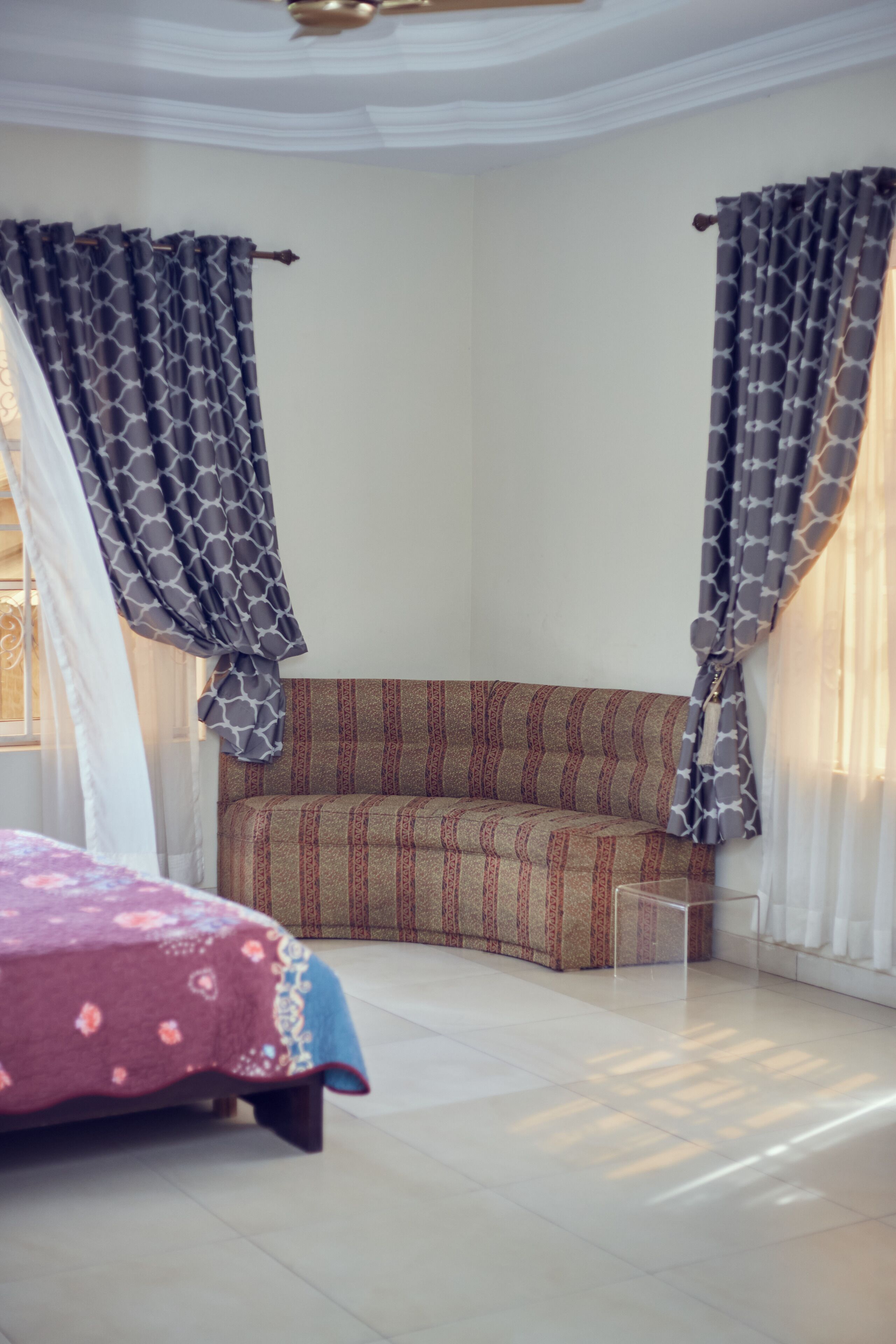 Ein Schlafzimmer mit Bett, einer Couch und Vorhängen.