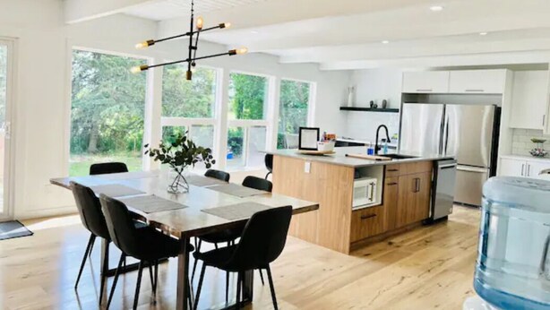 A modern kitchen with a wooden island, stainless steel appliances, and a large water dispenser.