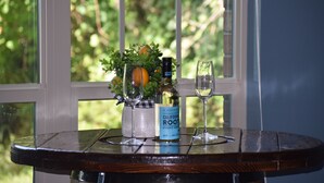 A table with a bottle of California Root Pinot Grigio, two glasses, and a potted plant with an orange. - Spacious Conroe Home < 4 miles to the Lake! (Montgomery)