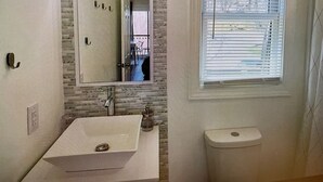 A bathroom with a sink, mirror, toilet, and window. - Cozy Elk Hideaway - Walk to Ski Slopes!!! (Beech Mountain)
