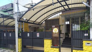 Una entrada protegida con un muro amarillo y una reja de metal.