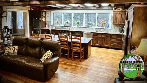 Una cocina acogedora con comedor, armarios de madera y una ventana con flores.