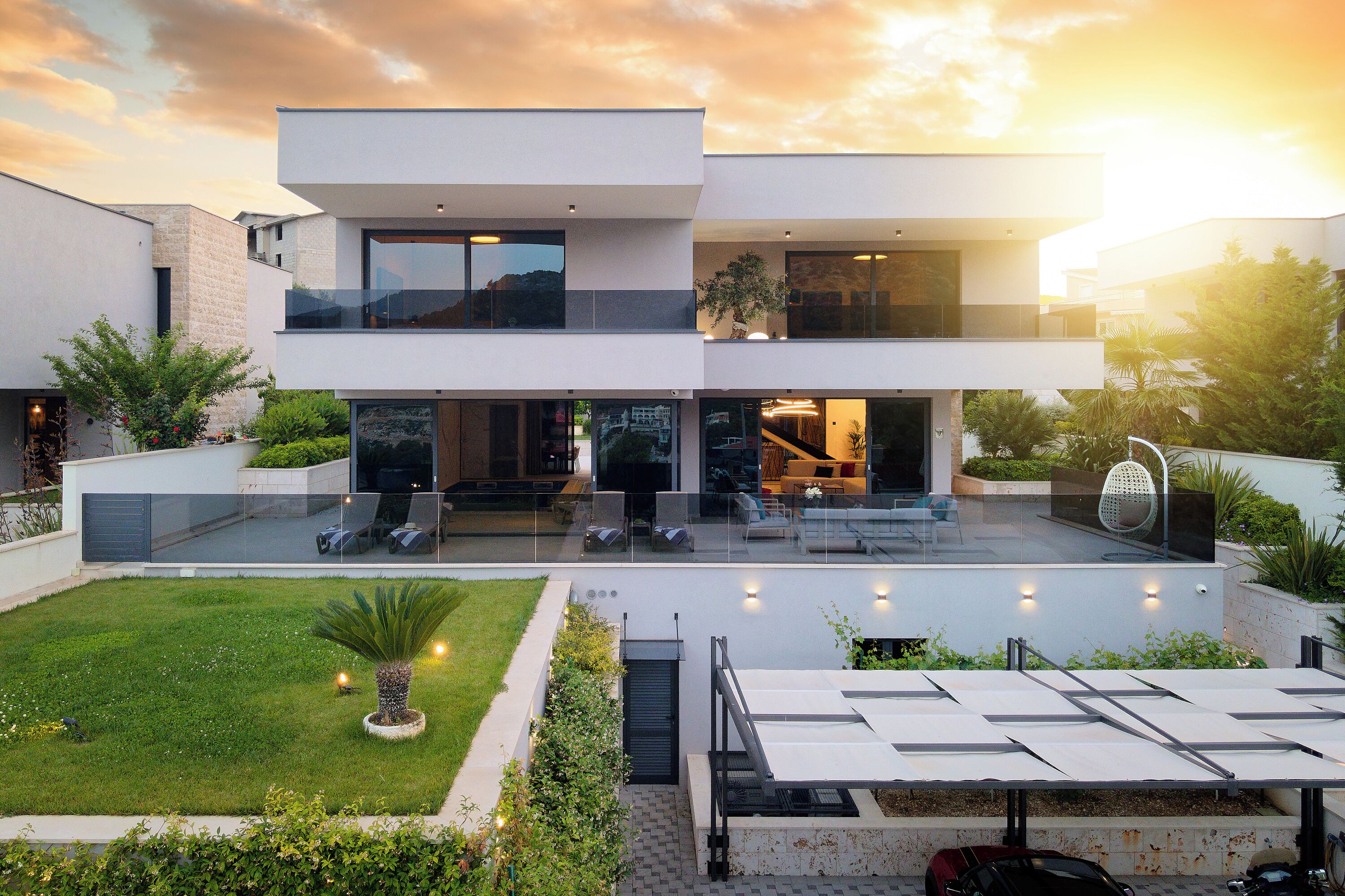 A modern two-story house with a spacious outdoor area, including a patio and solar panels.