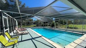 Una piscina scoperta coperta con lettini e una vista aperta sui dintorni.