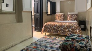 Une chambre à coucher avec un lit, un tapis à motifs et une table de chevet.