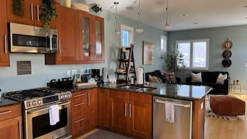 A modern kitchen with stainless steel appliances, wooden cabinets, and a central island.