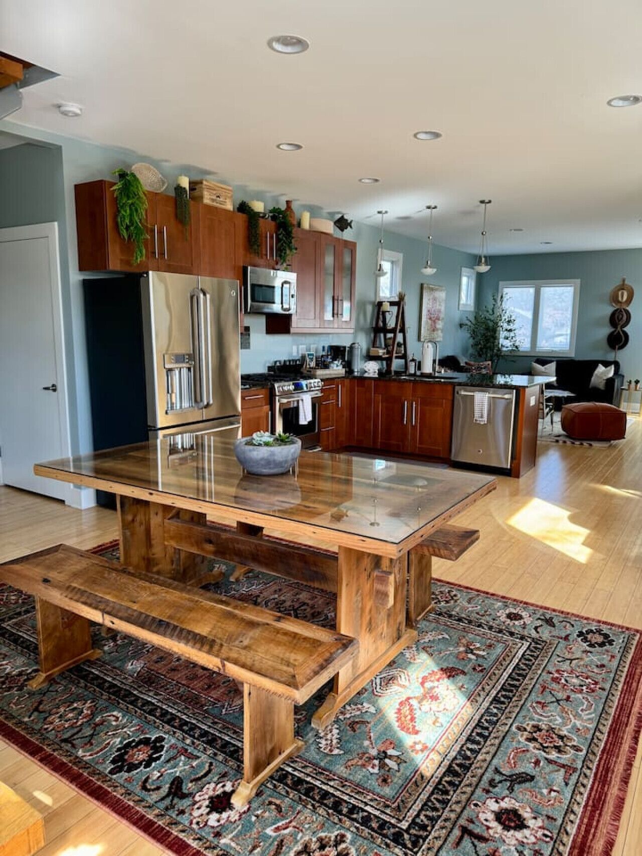 A modern kitchen with wooden cabinets, stainless steel appliances, and a central island.