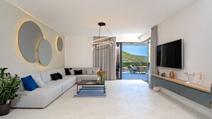 Ein modernes Wohnzimmer mit einer Couch, einem Couchtisch und einem Fernseher.