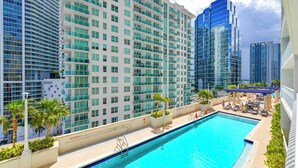 A hotel pool area with a clear view of high-rise buildings in the background. - Stylish 1BR | Free Parking | Near Kaseya Center (Miami)