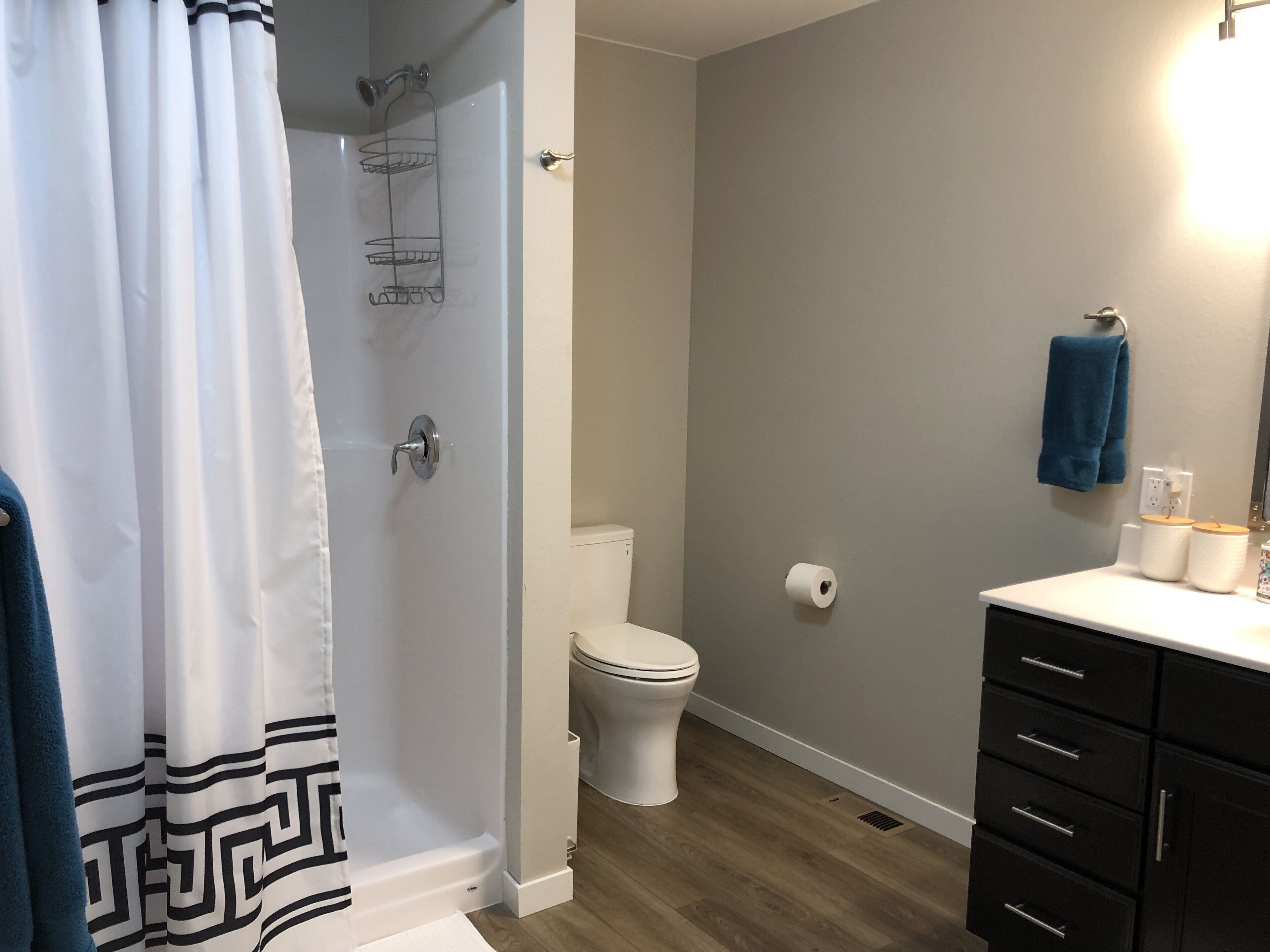 Un bagno con doccia, toilette e lavabo, con un asciugamano appeso al muro.