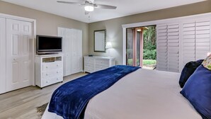 A bedroom with a bed, a television, a dresser, and a ceiling fan. - Pet & EV-Friendly Fairway Oaks, Steps to Golf! (Fernandina Beach)