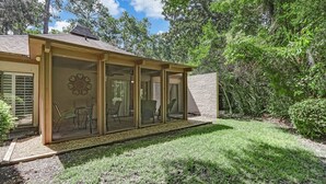 A house with a covered patio area, large glass doors, and a well-maintained lawn. - Pet & EV-Friendly Fairway Oaks, Steps to Golf! (Fernandina Beach)