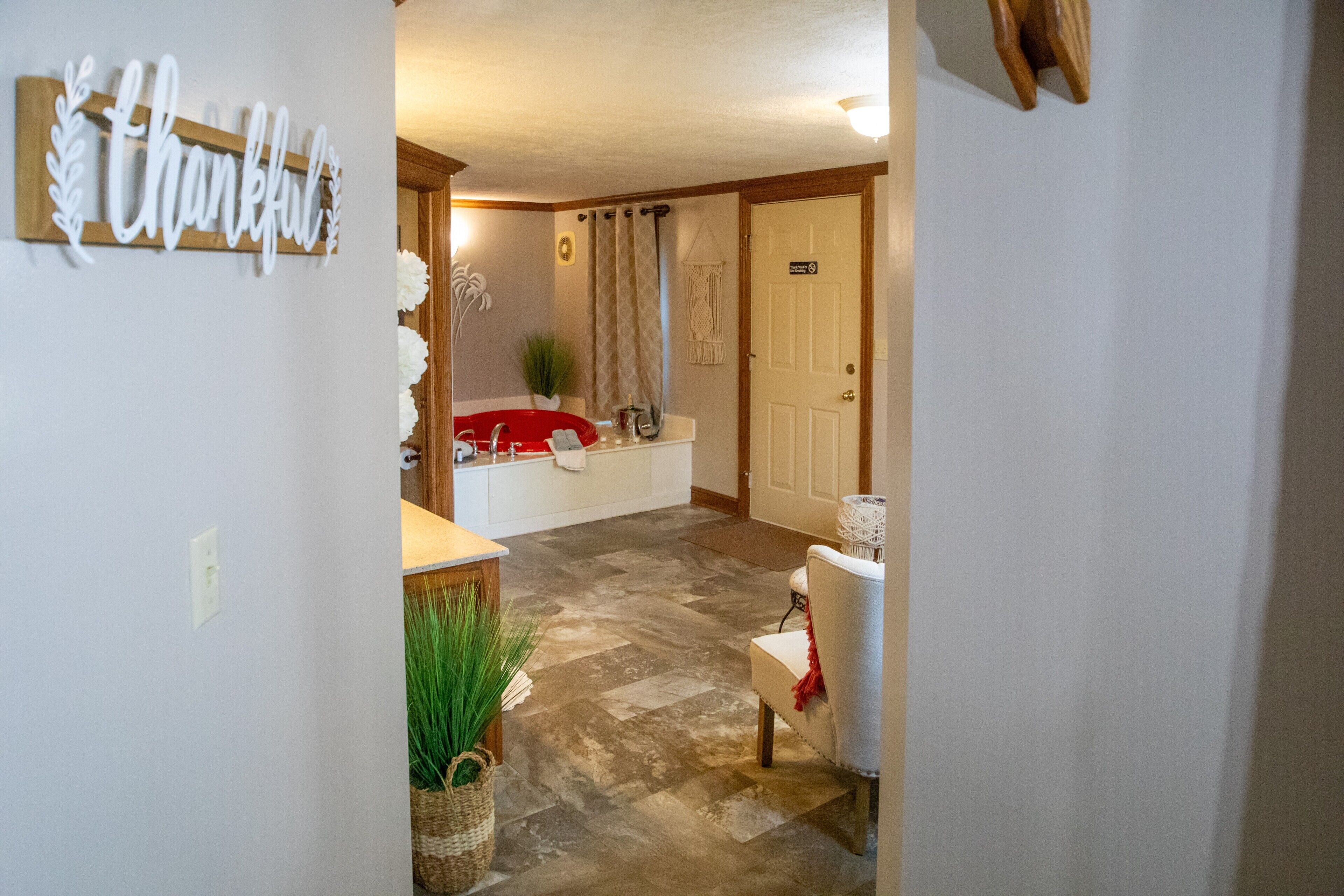 A hotel bathroom with a red bathtub, a white sink, and a towel rack.