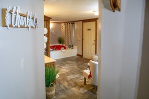 Un baño de hotel con una bañera roja, un lavamanos blanco y un perchero para toallas.