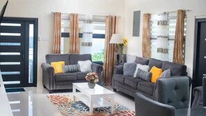 A modern living room with two sofas, a coffee table, and a lamp.