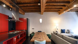 A modern kitchen with red cabinetry and a wooden dining table. - Piazza Navona Mara’s apartment (Roma)