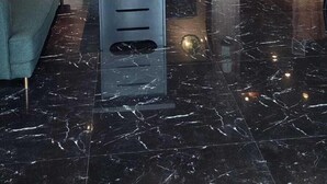 Un hall d’entrée moderne avec un sol en marbre, un plafond en bois et un comptoir d’accueil.