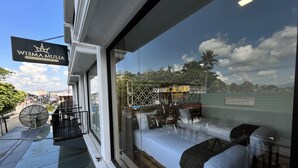 Une chambre d’hôtel avec une grande fenêtre, un balcon et une enseigne indiquant « Wisma Mulia ».