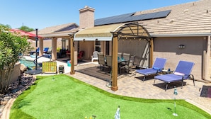 A backyard with a pool, a covered patio area, and a lawn with a putting green. - Resort Style Home, Private"Heated Pool", Near Phoenix.Putting Green, Pool Table. (Mesa)