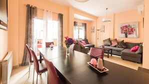 Una sala de estar moderna con comedor, que incluye un conjunto de sofá, una mesa de centro y una mesa de comedor con sillas.
