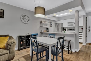 A modern kitchen with white cabinets, a stainless steel refrigerator, and a built-in microwave.