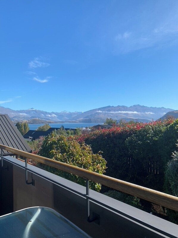 A balcony with a view of mountains and a lake.