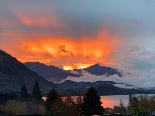 A mountainous landscape with a lake and a sunset. - AspiringLofts (Wanaka)