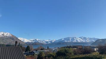 A view of a mountainous landscape with snow-capped peaks and a body of water in the foreground.