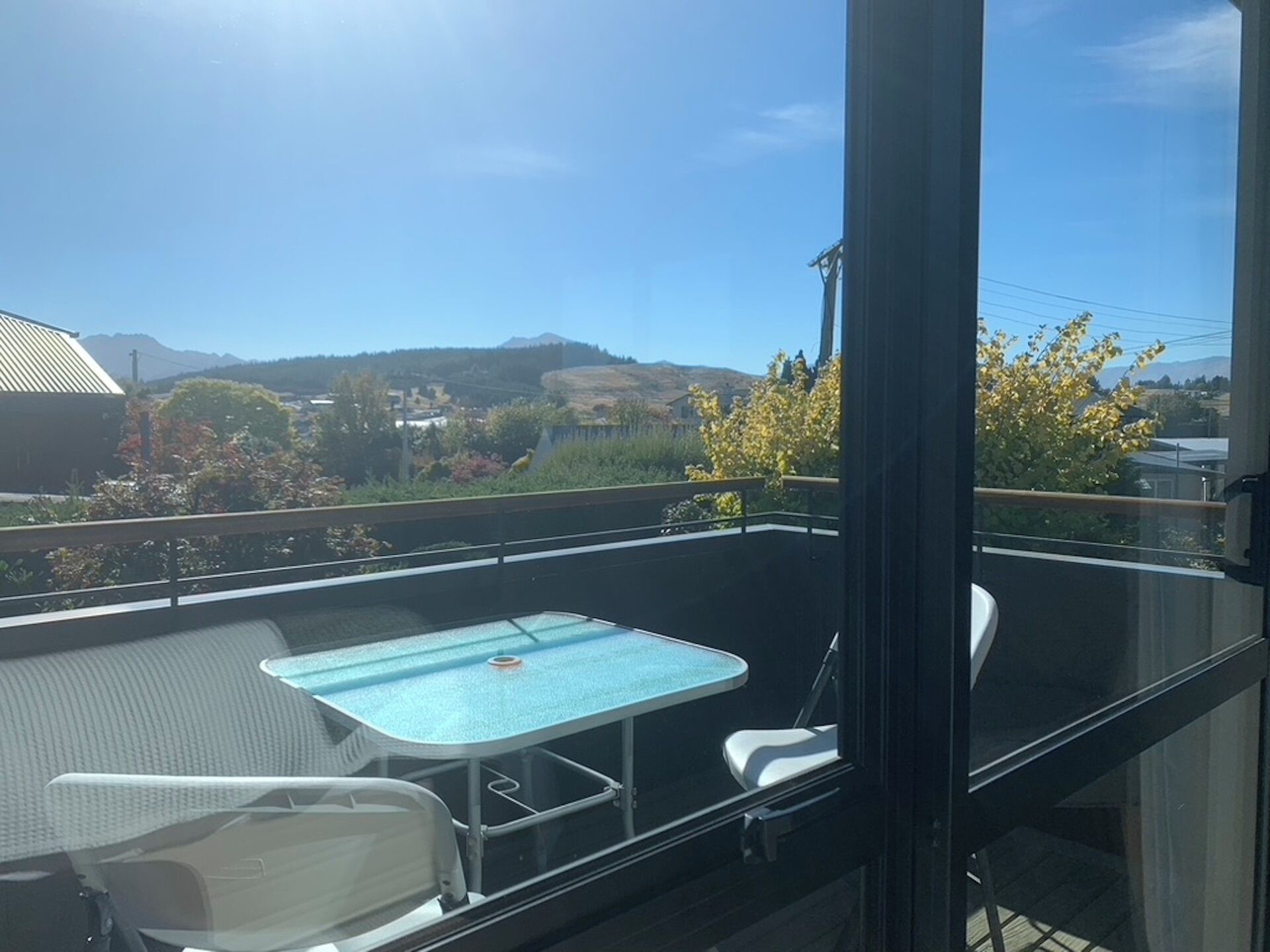 Un balcón con mesa de billar, sillas y vistas a un paisaje montañoso.